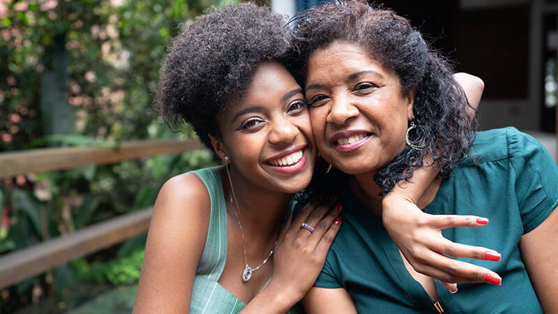 Photo of African American mother and daughter hugging