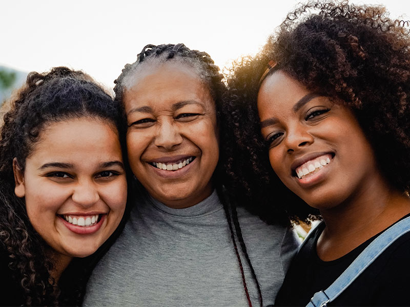 Photo of three happy African American women smiling for the camera